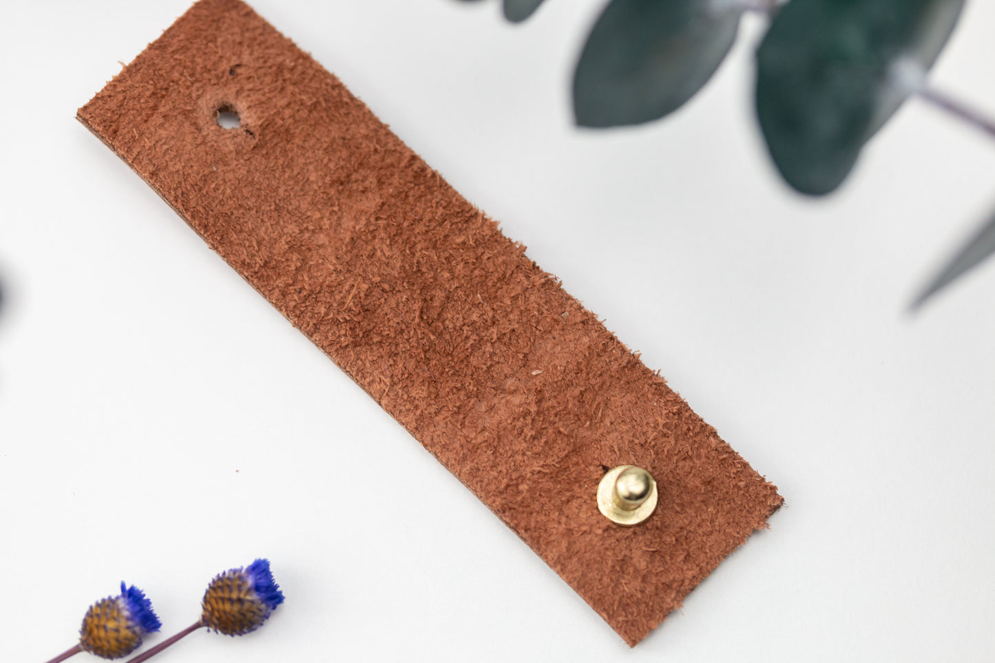 Rich brown full-grain leather cable wrap, carefully finished by Keyaiira with brass stud & post hardware for securing earbuds, charging cords and frequently used electronic cables
