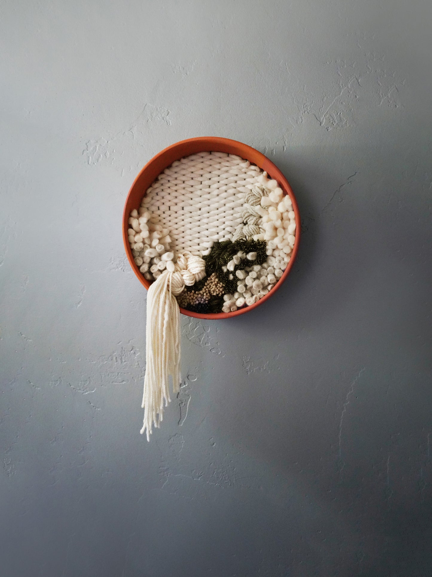 Textural modern wall decor by Keyaiira handcrafted wool and felt in earthy tones framed by terracotta, ideal for minimalist home interiors.