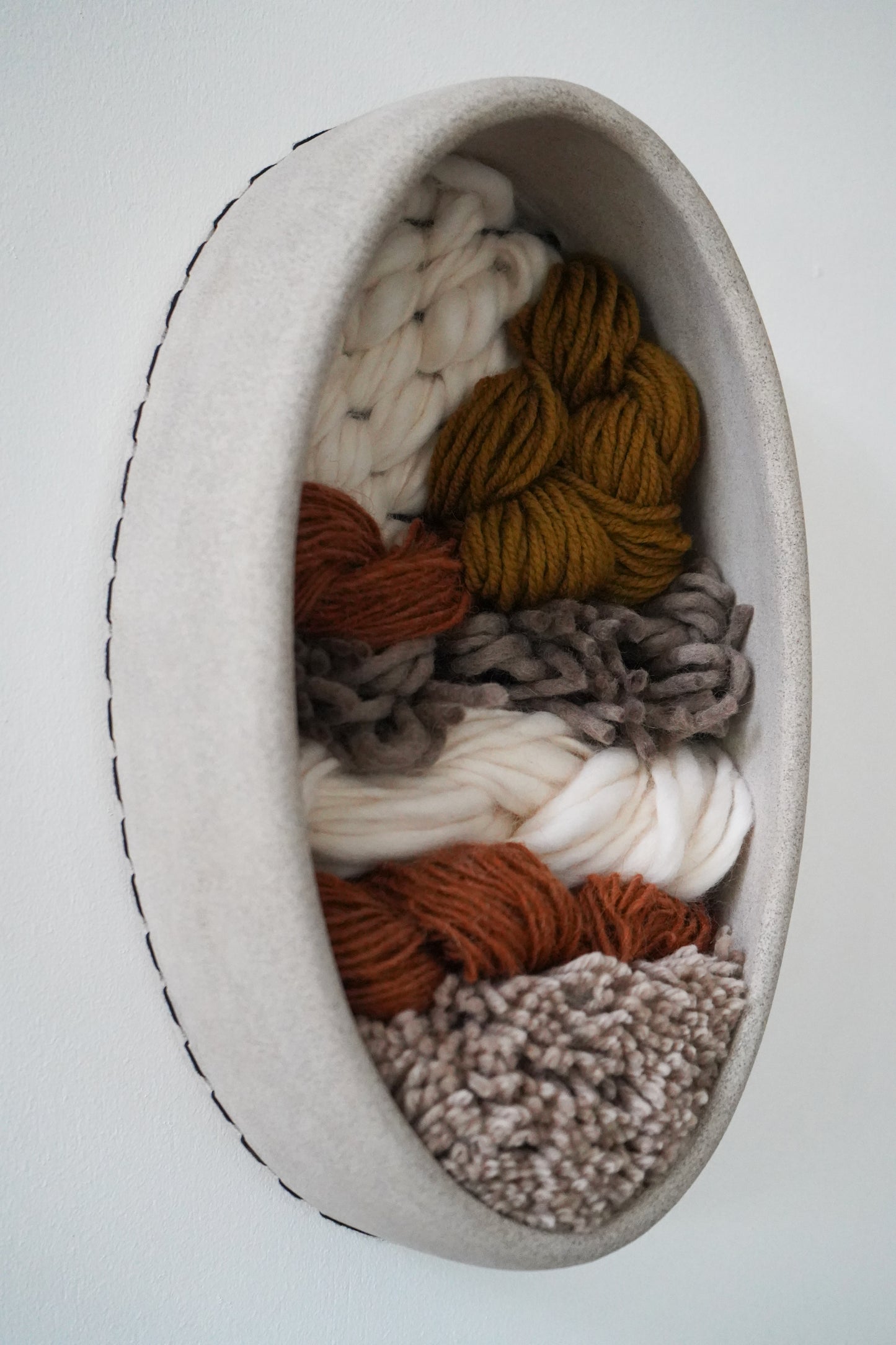 Modern organic wall sculpture blending clay, wool, and natural yarns, handcrafted in Northern California for sustainable home styling