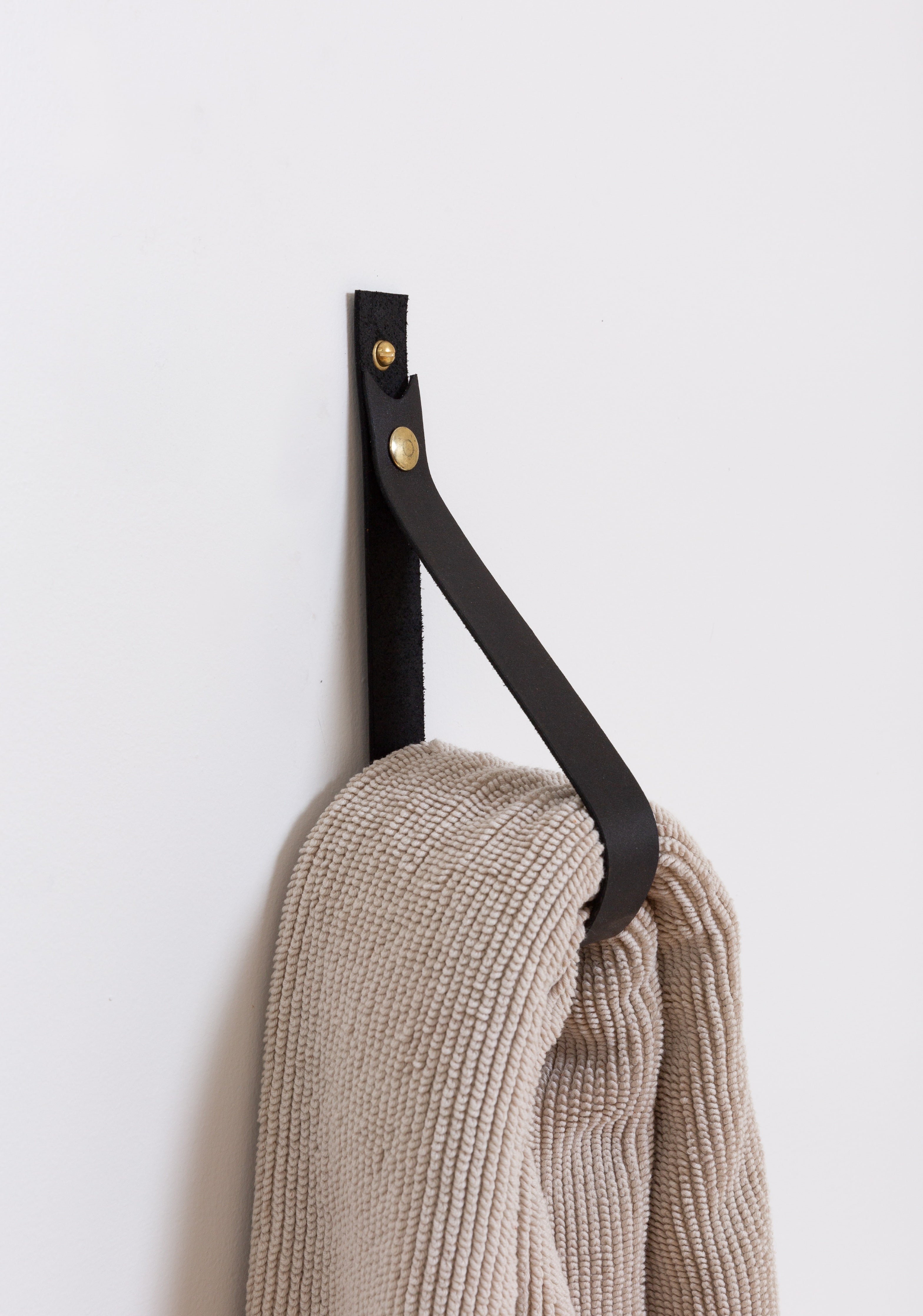 Swivel snap fastener with leather beige bag strap on a wooden