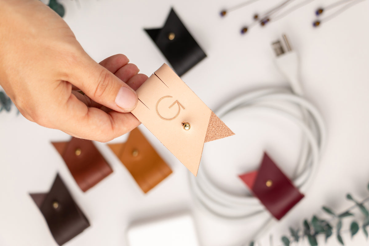 Custom-lettered Veg Tan leather cord holder with G initial, made-to-order by Keyaiira for charging cables, USB wires, headphones, tech accessories and personalized everyday organization

