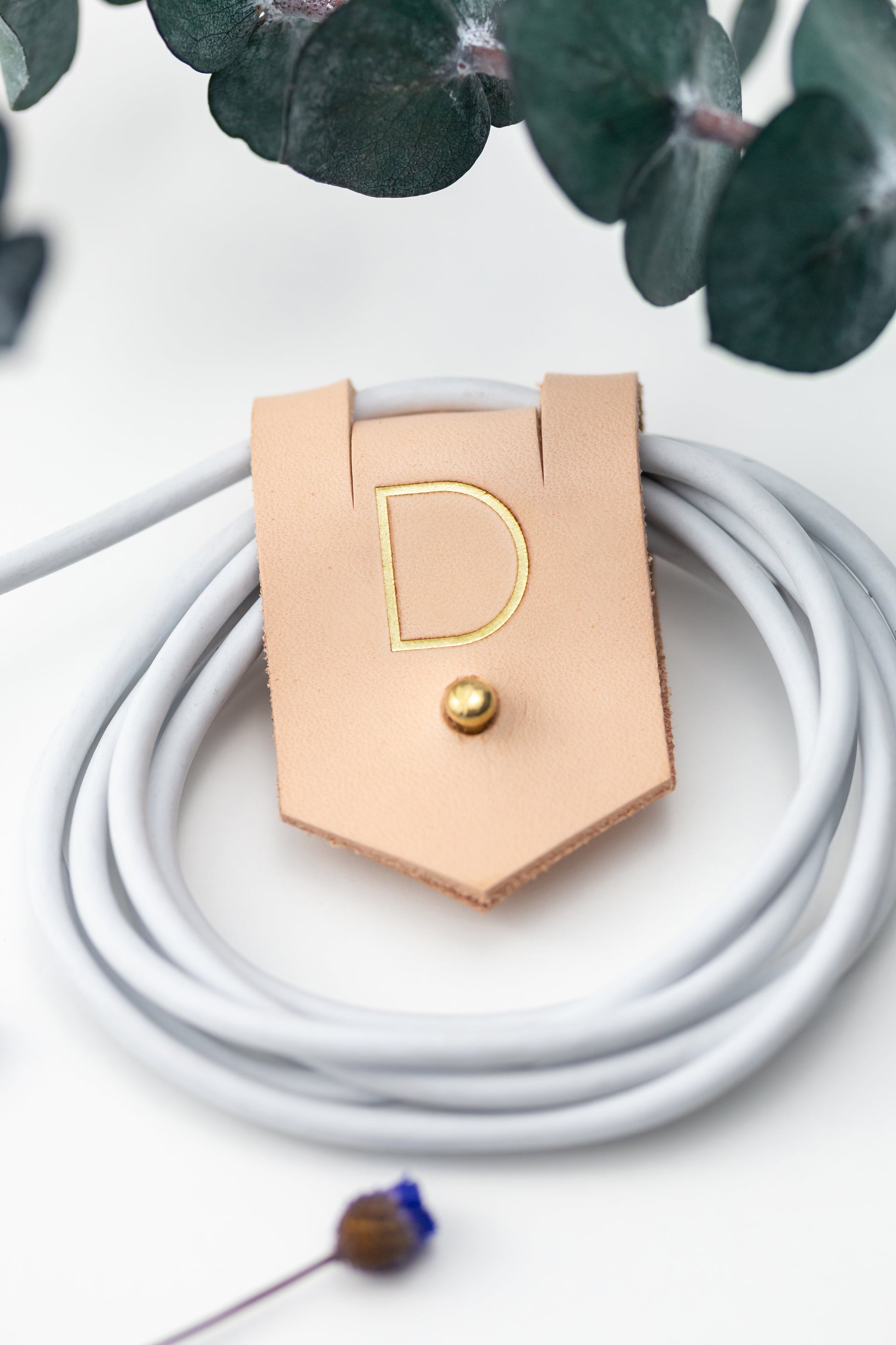 Personalized Veg Tan leather charger cord keeper with D initial, Stud & Post closure for coiled charging cables, USB cords, device cables and compact electronics storage by Keyaiira
