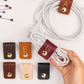 Personalized initial leather cord holders in assorted Keyaiira colors, designed for charging cables, USB cords, computer accessories, electronics and convenient cable management
