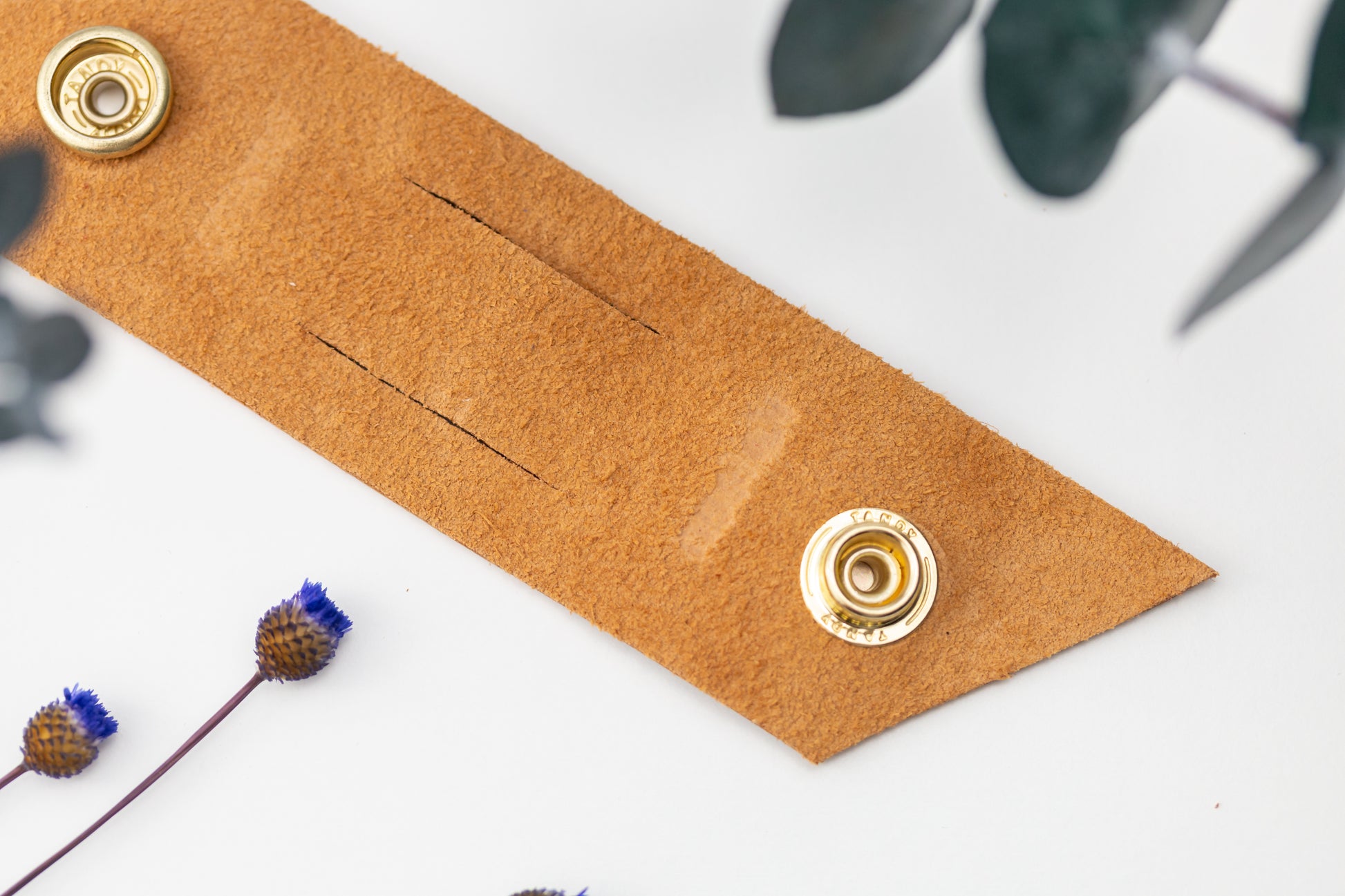 Genuine Cognac leather cable management strap with brass snap hardware, handcrafted by Keyaiira for bulky charger cords, power cables, computer wires and home office organization
