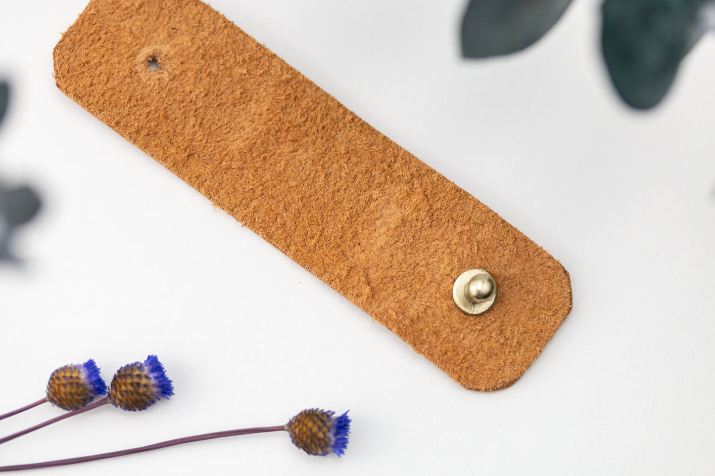 Nicotine full-grain leather cable management strap with brass hardware, hand-finished by Keyaiira for phone charger cords, USB cables, electronics accessories and streamlined desk storage
