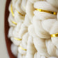Macro view of sustainable fiber art materials. Detailed shot of cloud-like wool loops sourced from Cedarville, CA, demonstrating the high-relief texture and premium quality of the Fibershed Certified™ materials.