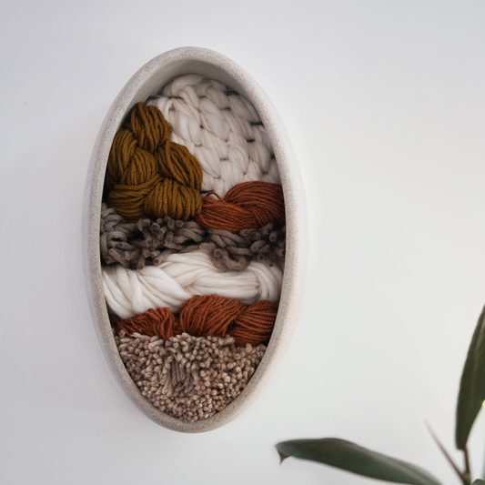 Oval Sculptural mixed media wall piece featuring clay and handwoven fibers, minimalist organic design for Japandi and modern interiors