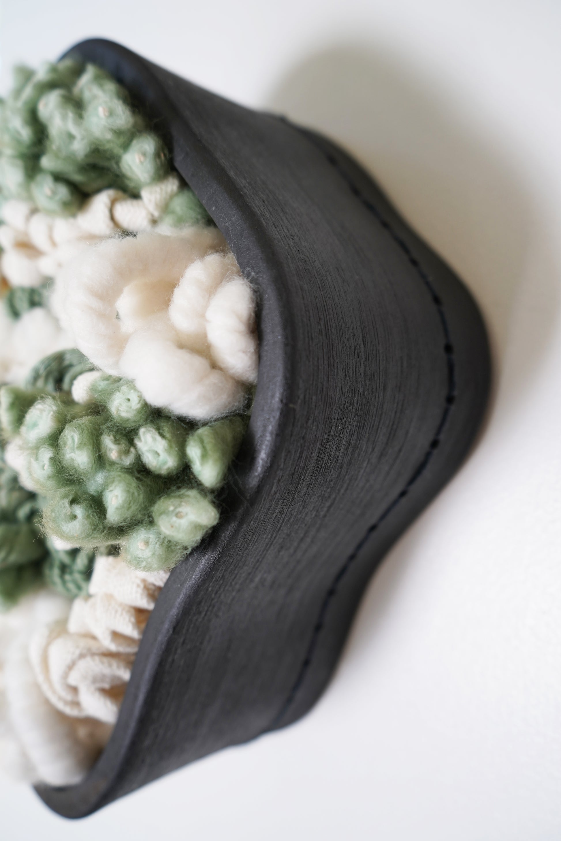 Side-angle view of the fiber art piece highlighting the 5-inch depth of the hand-formed clay frame. Shows the three-dimensional, layered construction of the lush organic cotton and merino wool blend, demonstrating its substantial wall presence.