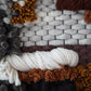 Macrophtography of textured woven wool and leather accents.