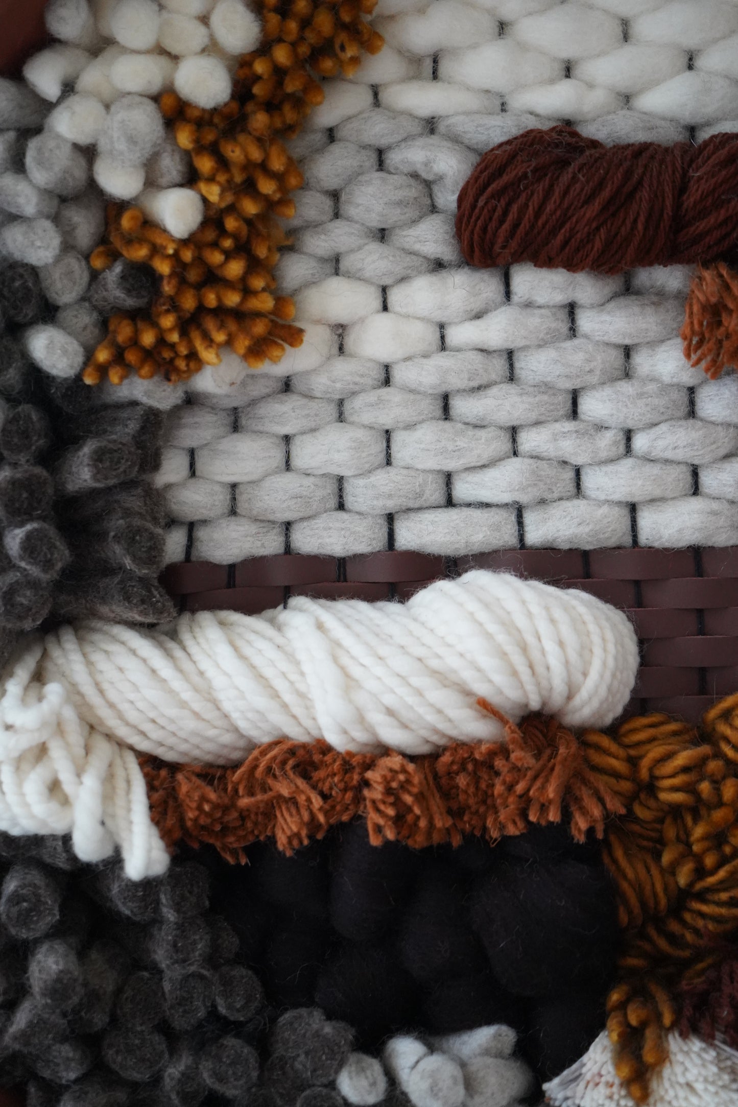 Macrophtography of textured woven wool and leather accents.