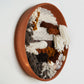 Side profile of clay wall art showing deep texture of woven fibers with earthy tones on a white wall, handmade by Keyaiira