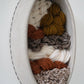 Modern organic wall sculpture blending clay, wool, and natural yarns, handcrafted in Northern California for sustainable home styling