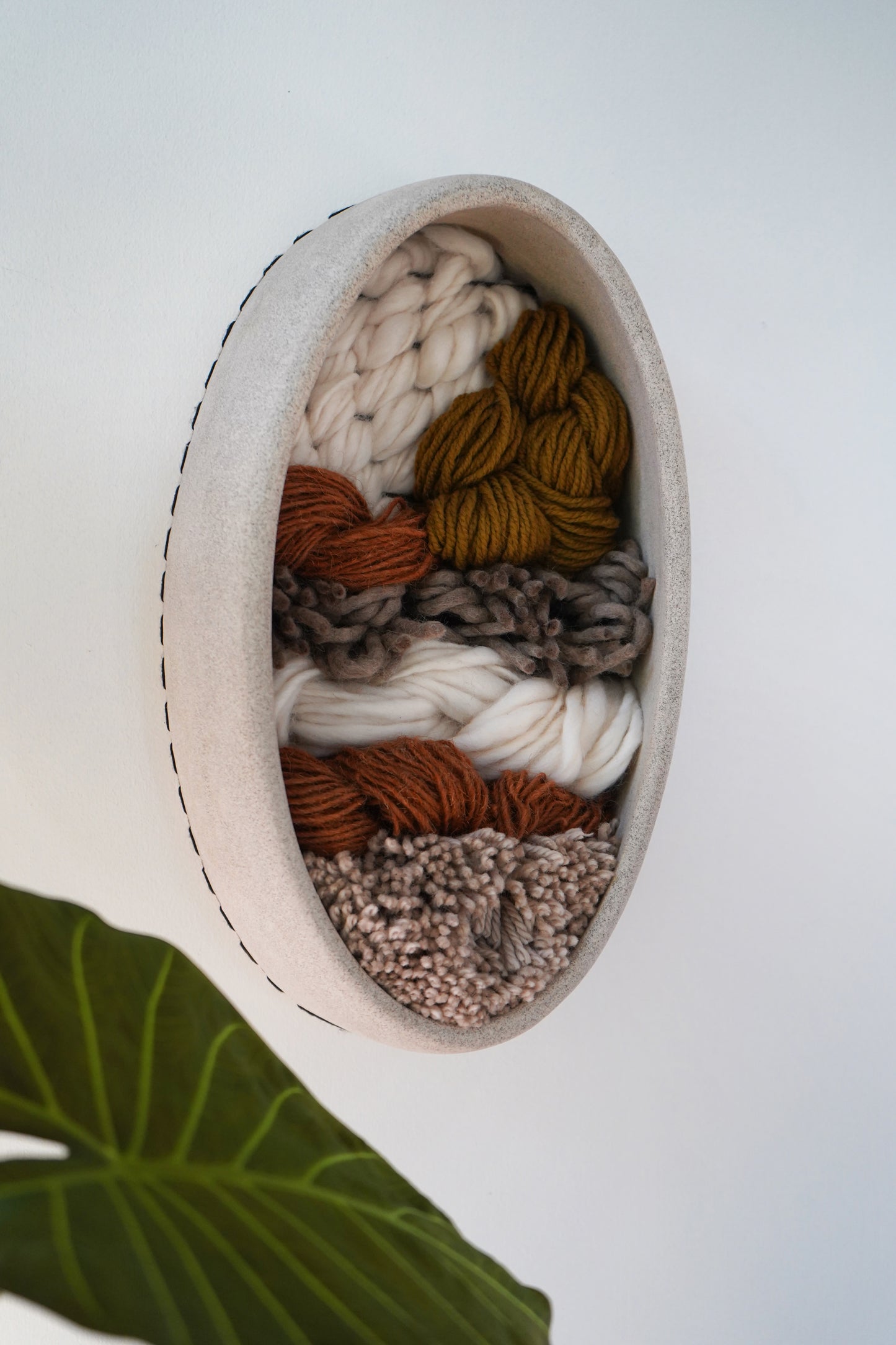 Artisan-crafted clay and wool wall hanging, a textural neutral statement piece for eco-conscious and design-forward homes.