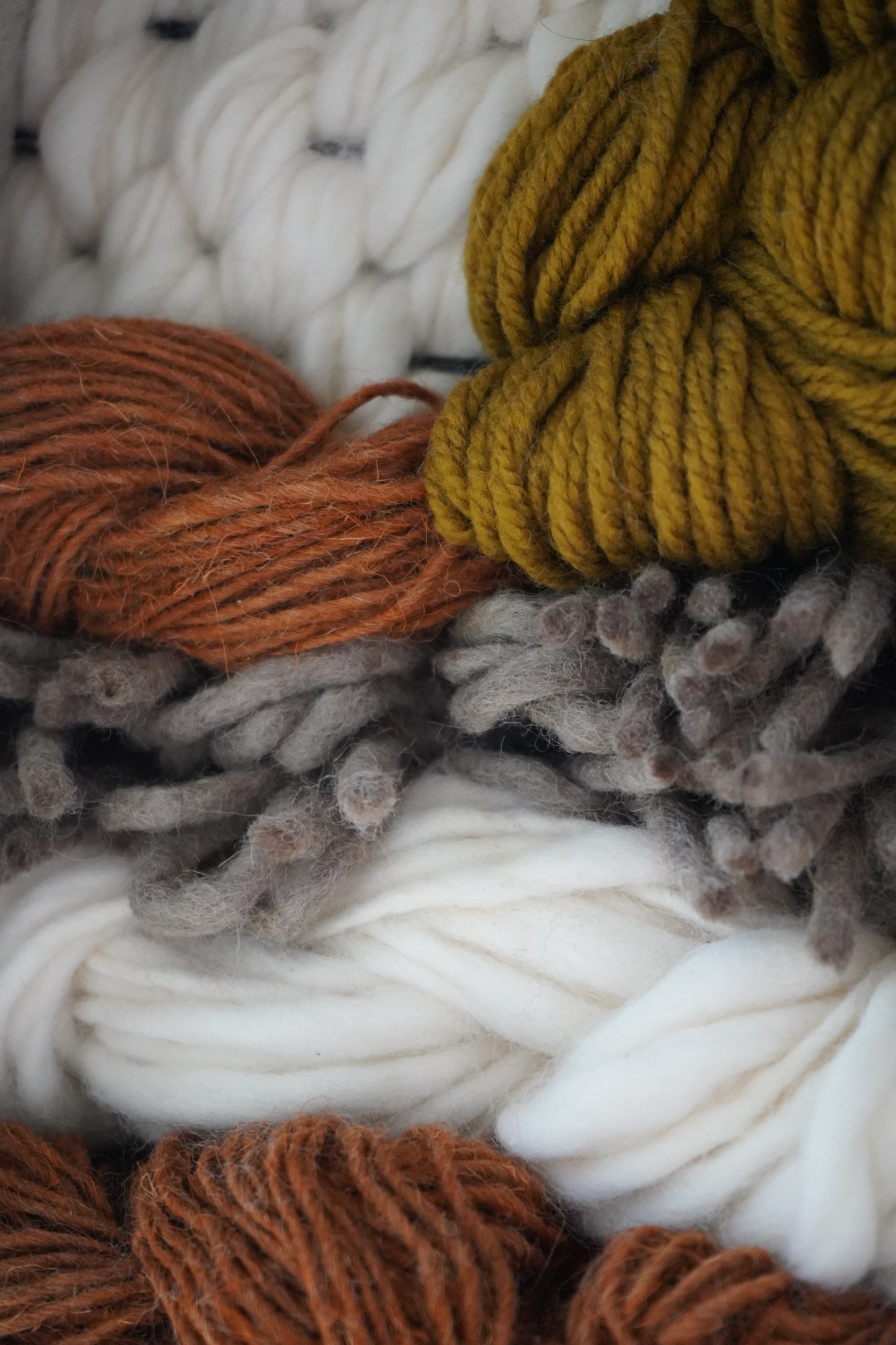 close up detailed view of wool and yarn textures inside a smooth clay frame, showcasing artisan craftsmanship and earthy modern design by Keyaiira.