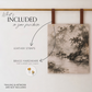 A canvas wall art print with a monochrome landscape painting is displayed hanging from two brown leather straps on a gold rod against a white wall. Text on the left lists included items: leather straps, brass hardware, and a small round sample of brass hardware.