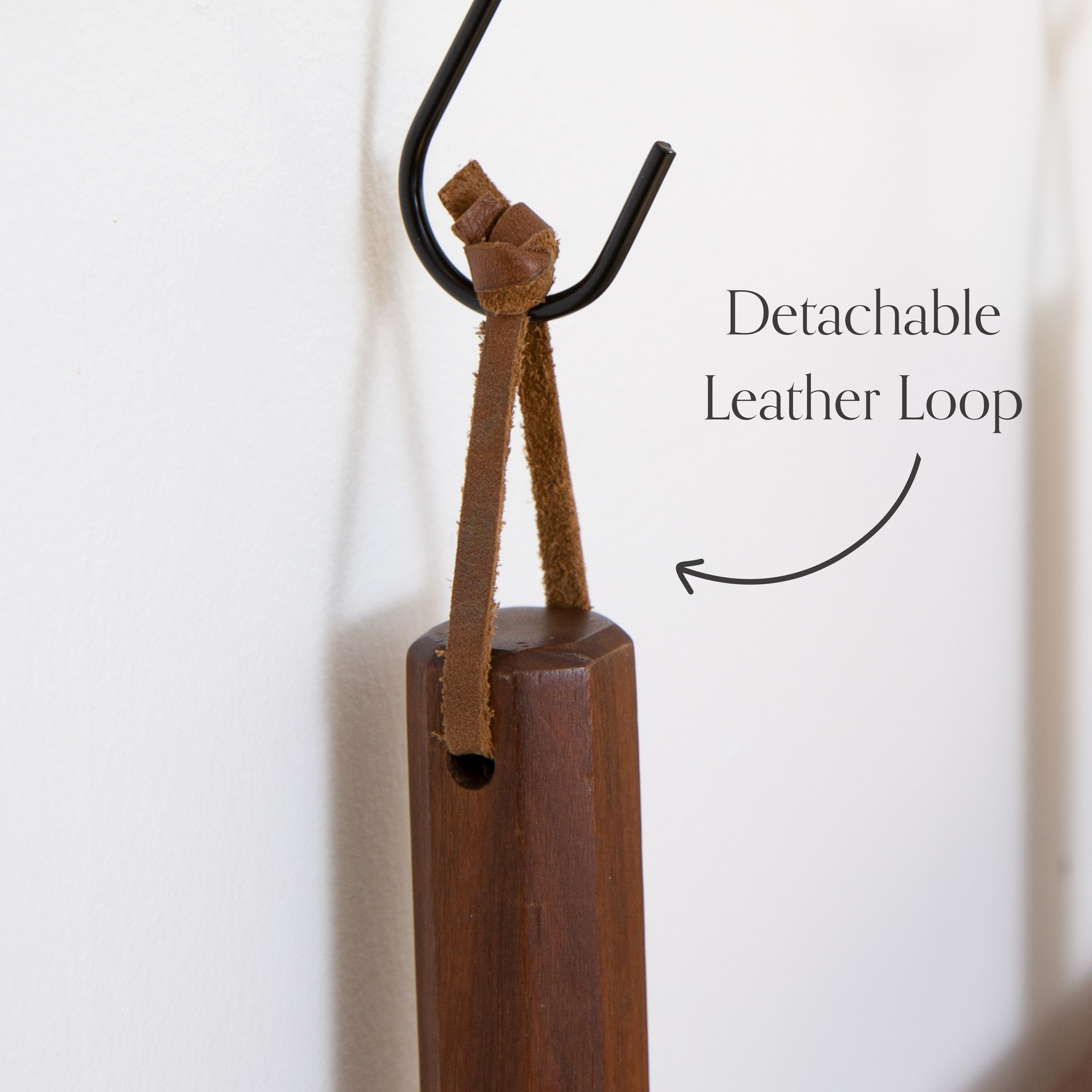 Detachable leather hanging strings by Keyaiira shown hanging from a wall hook, highlighting the removable leather string design with brass screw hardware.