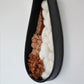 Side angle of the clay wall art highlighting the depth of the hand formed black clay vessel and the soft, plush fiber textures inside. Shows the three dimensional structure clearly.