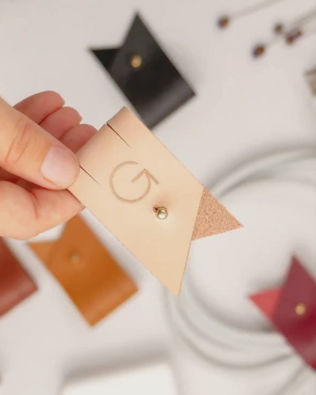Keyaiira large leather cable holder demonstration featuring a custom G initial and Stud & Post hardware for securing charging cords, device cables and tech accessories
