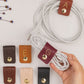 Keyaiira large leather cable holder demonstration showing custom initial options and snap hardware for organizing charging cables, USB cords, power cords and everyday tech accessories
